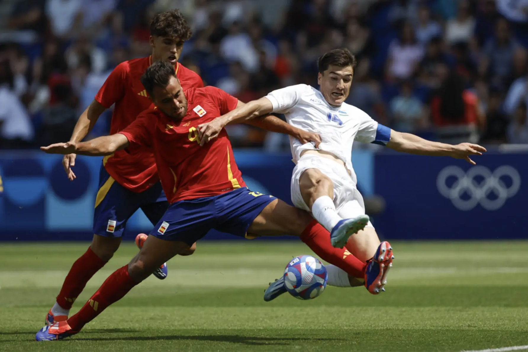 Tiền đạo Eldor Shomurodov (áo trắng) tranh chấp với trung vệ Eric Garcia, ở trận Uzbekistan thua Tây Ban Nha 1-2, tại lượt ra quân bảng C môn bóng đá nam Olympic 2024. Ảnh: AP